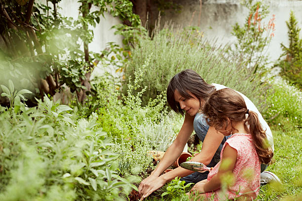 Mother and daughter planting together in garden